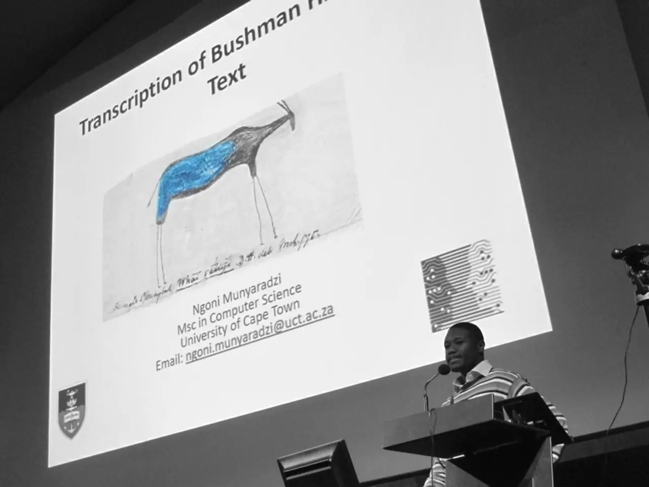 At the bottom of the image there is a podium with mic. Behind the podium there is a man. Beside him...