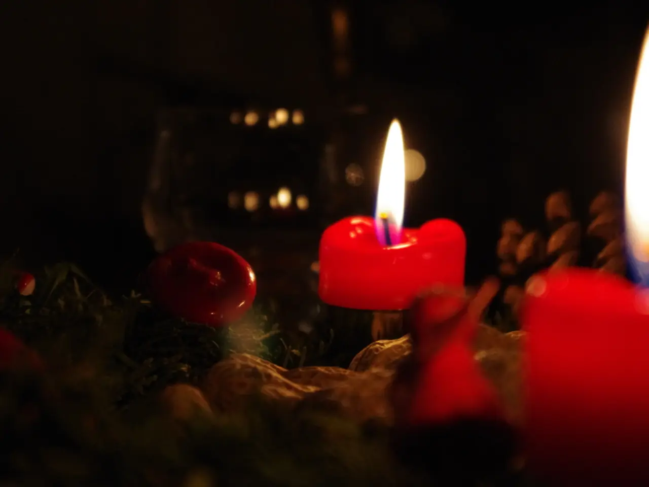 In this image we can see red color candles are burning.
