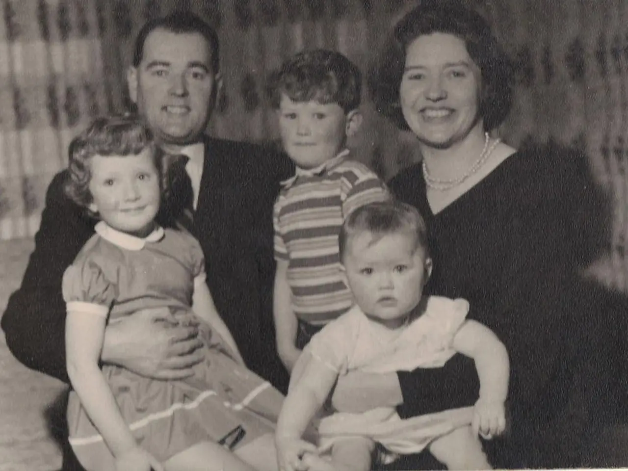 In this image we can see a family of five persons. Here we can see a man on the left side is...