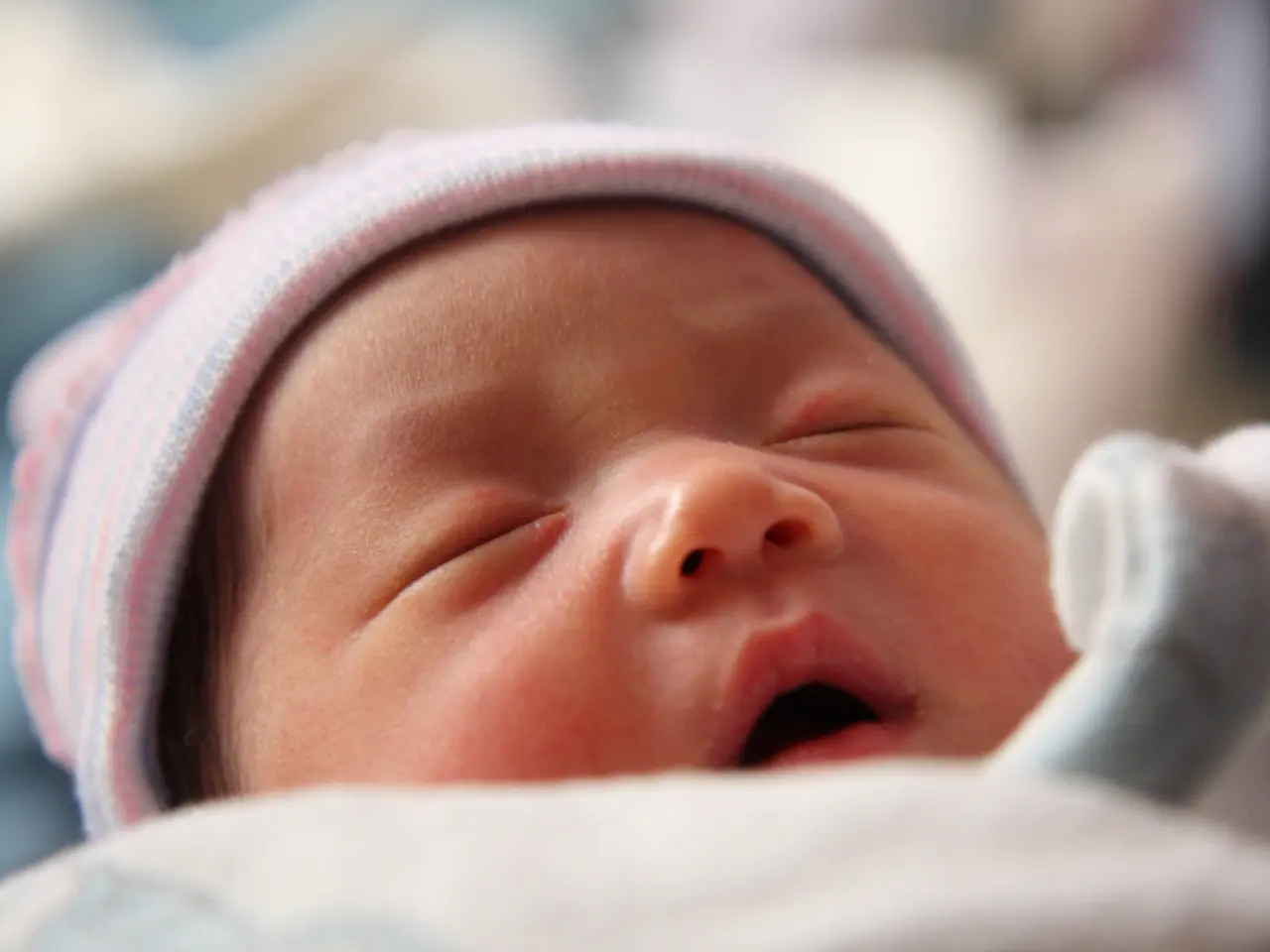 As we can see in the image there is a child sleeping in the front and the background is blurred.