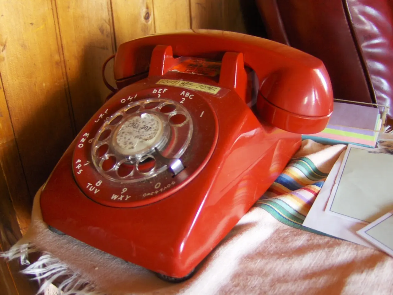 As we can see in the image there is a table. On table there is a phone and papers.