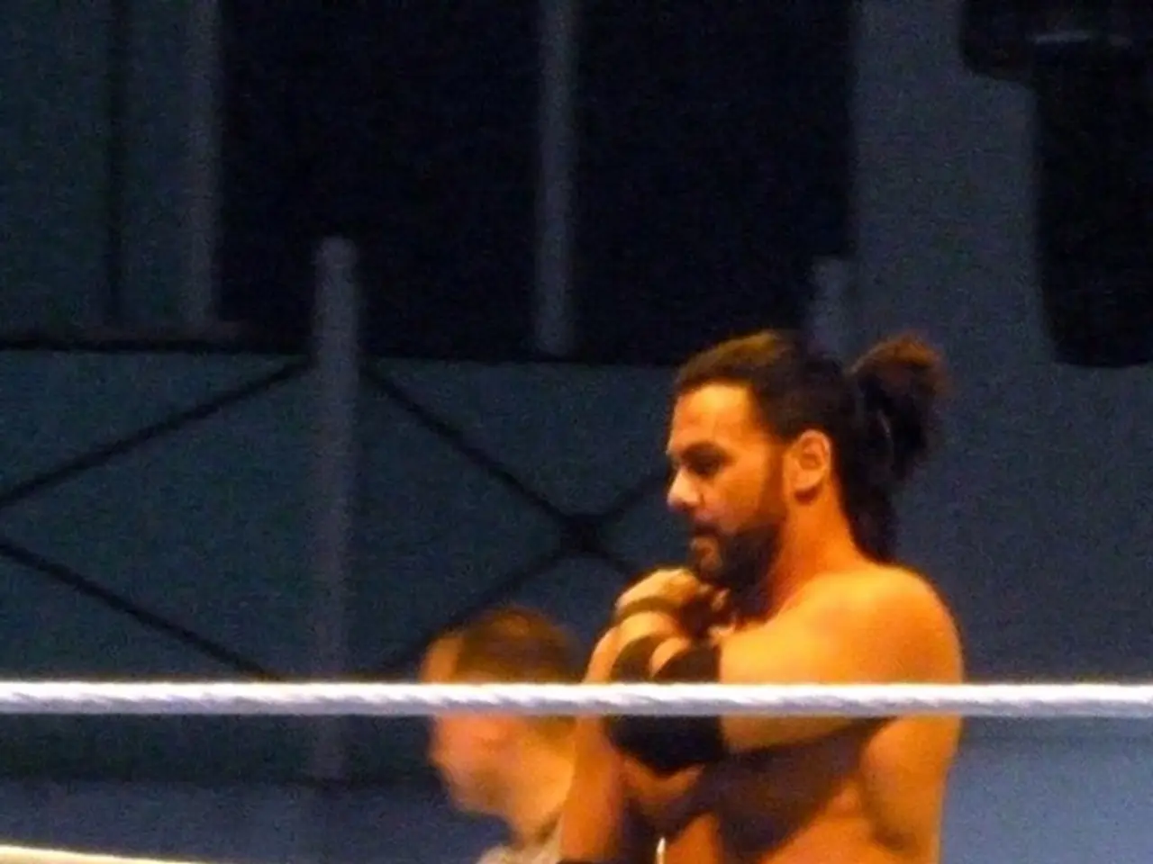 In this picture there are two men in the center of the image and there is a rope boundary in the...