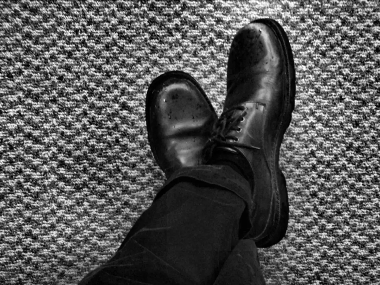 This is a black and white image. In this image we can see a book on the person's lap.