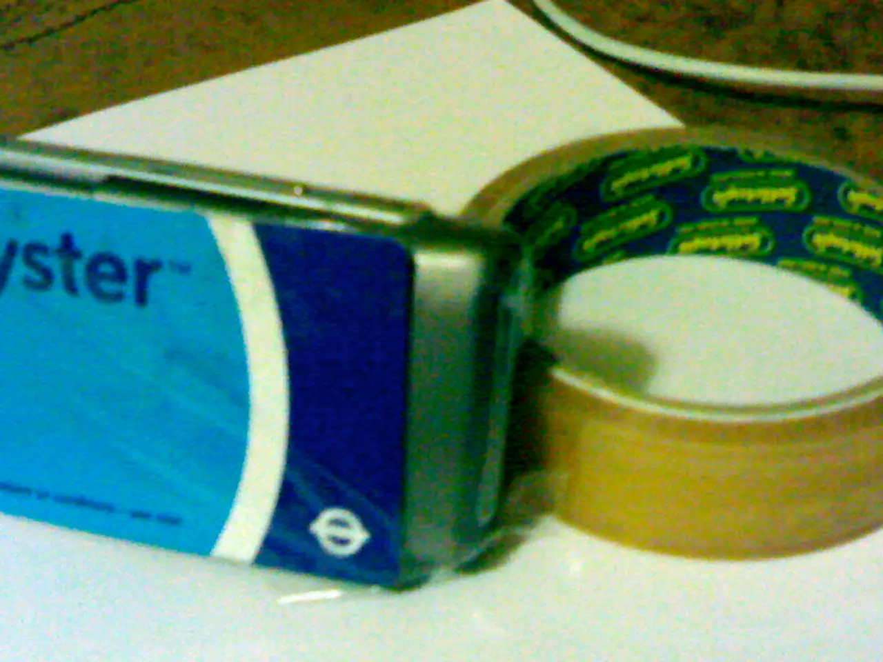 In this picture there is a tape which is placed on a white sheet and there is another object placed...