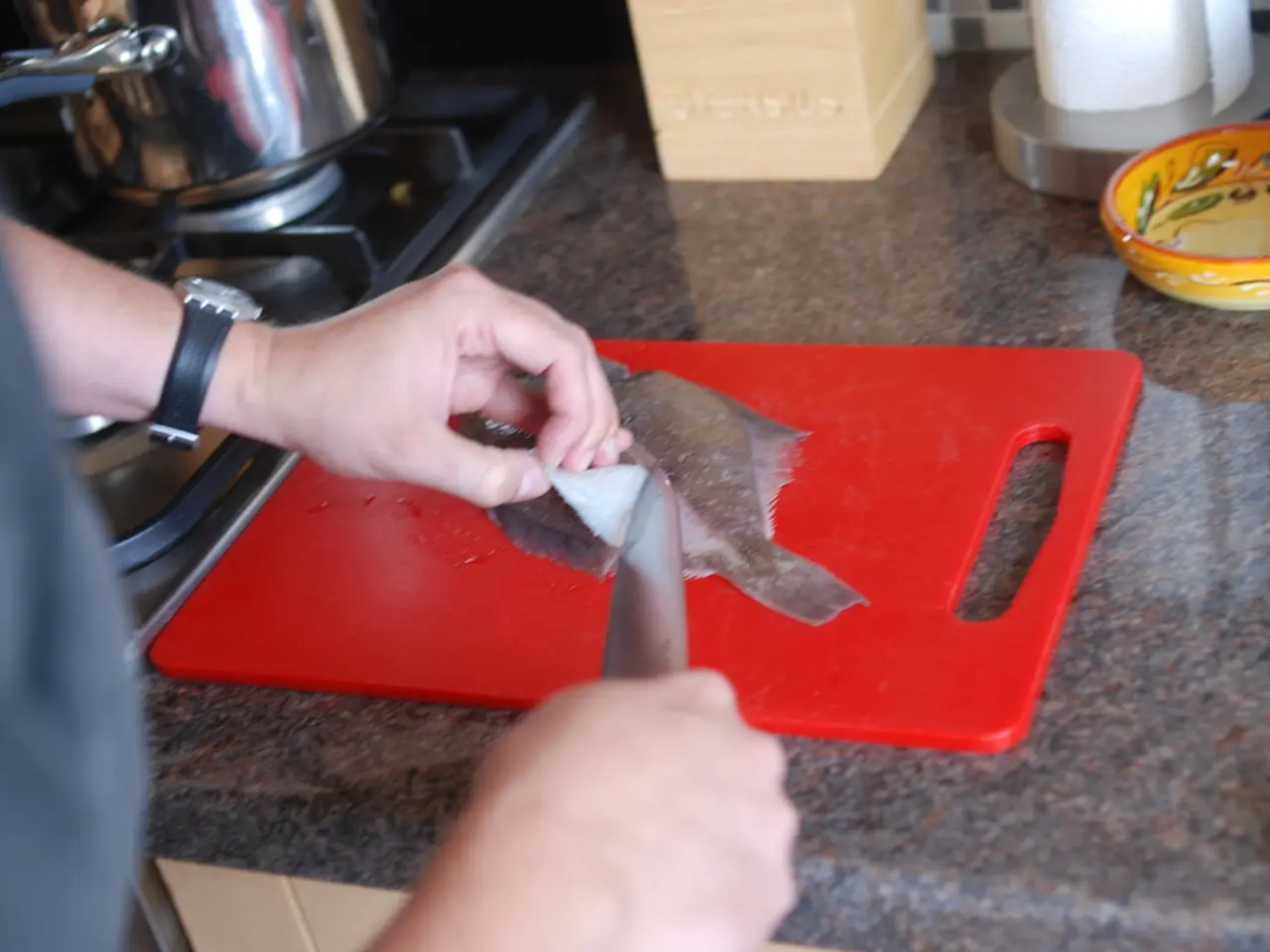 This image is taken indoors. On the left side of the image there is a man and he is holding a knife...