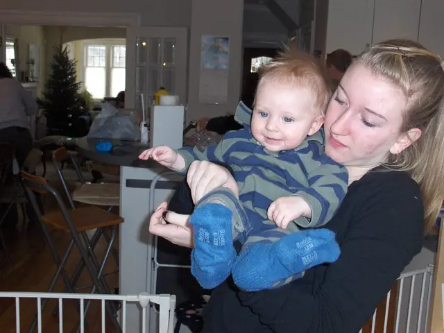 On the right side there is a lady holding a baby. Behind her there is a railing. In the back there...