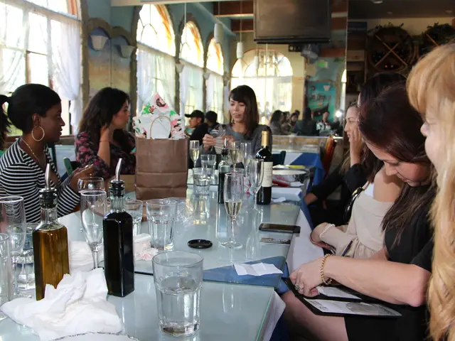 There is a group of people. They are sitting on a chair. There is a table. There is a...