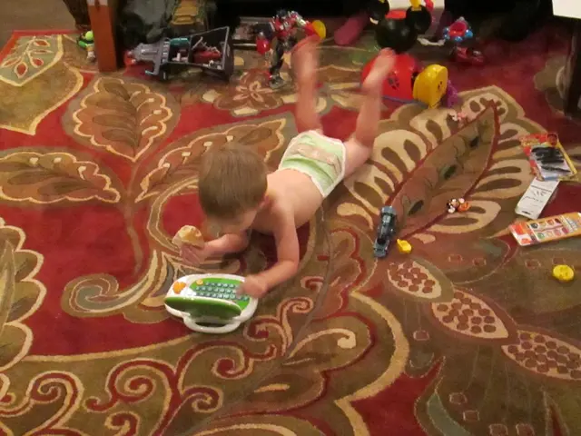 In the picture we can see a kid lying down and there are some toys around him.