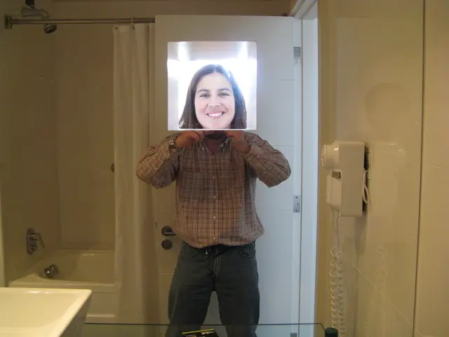 In this picture we can see a man standing in the washroom and holding the girl photo and keeping on...