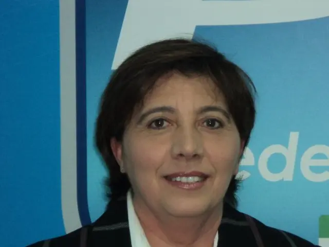 In this picture we can see a woman smiling, in the background there is some text.