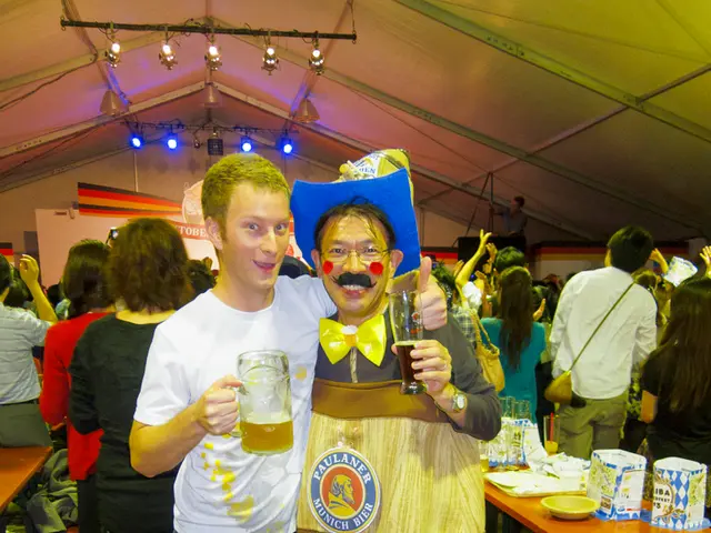 In this image there are two people standing together in which one of them is holding kid with beer...